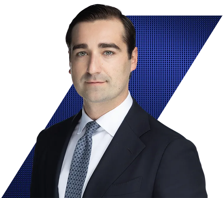 Headshot of a man in a dark suit and patterned tie against a black and blue geometric background.