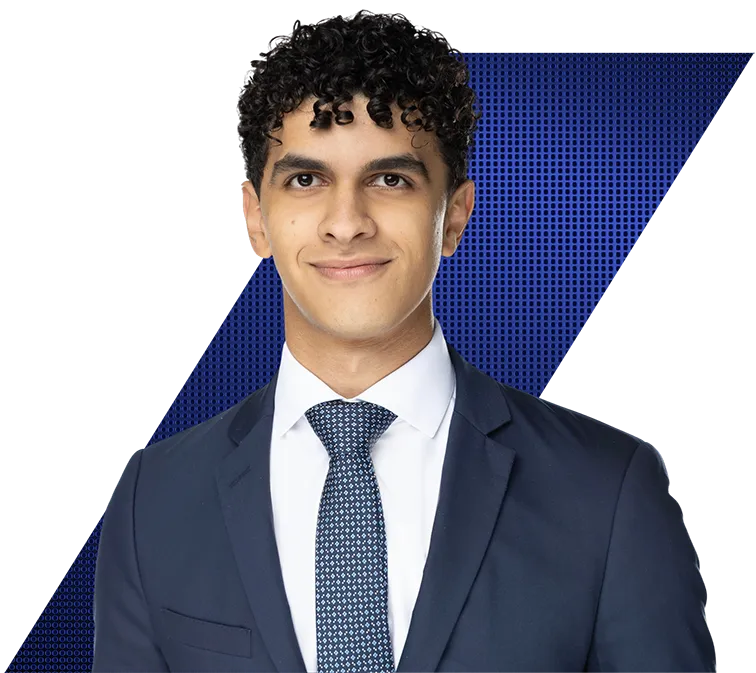 Headshot of a young man with curly hair wearing a dark blue suit and tie, smiling.