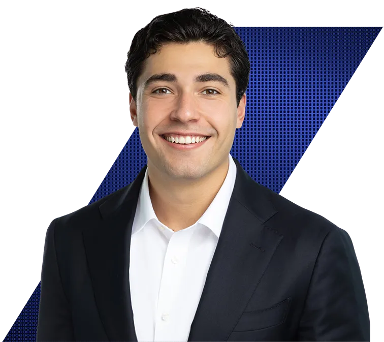 Headshot of a smiling young man in a dark suit and white shirt, against a black and blue patterned background.